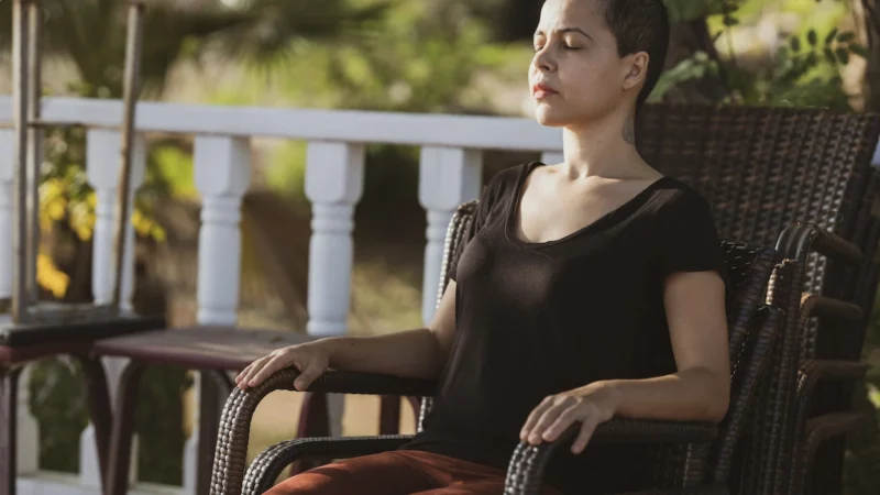 femme sur une chaise qui respire en conscience pour se détendre