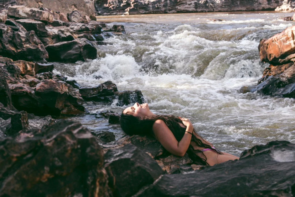 femme seule dans une rivière pour illustrer. la reconnexion à soi post partum